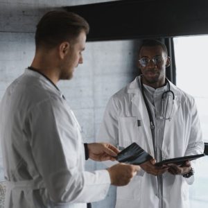Two medical professionals discuss research findings indoors.